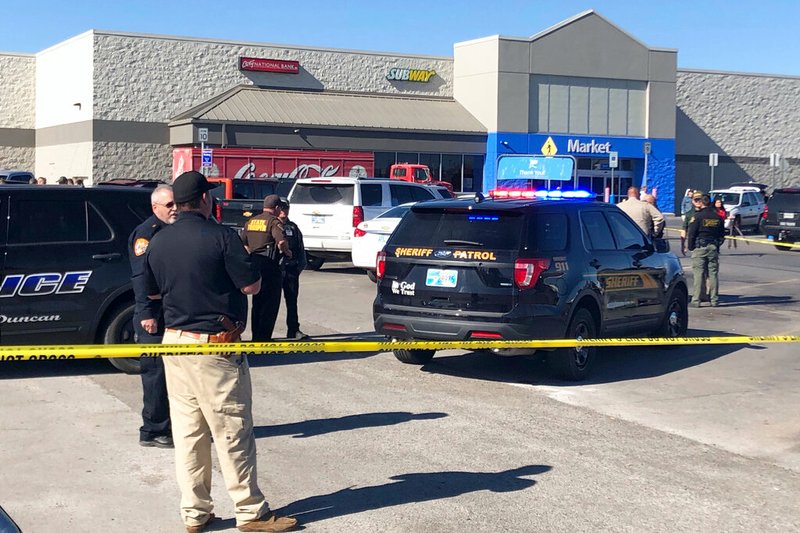 Law enforcement work the scene where two men and a woman were fatally shot Monday, Nov. 18, 2019, outside a Walmart store in Duncan, Okla. Two victims were shot inside a car and the third was in the parking lot outside the store in Duncan, Police Chief Danny Ford said.