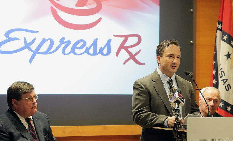 Galen Perkins, CEO of Express RX, talks about the company’s plans Monday at a news conference held at the Little Rock Regional Chamber of Commerce and attended by officials including chamber Chairman Kevin Crass (left) and Gov. Asa Hutchinson. 