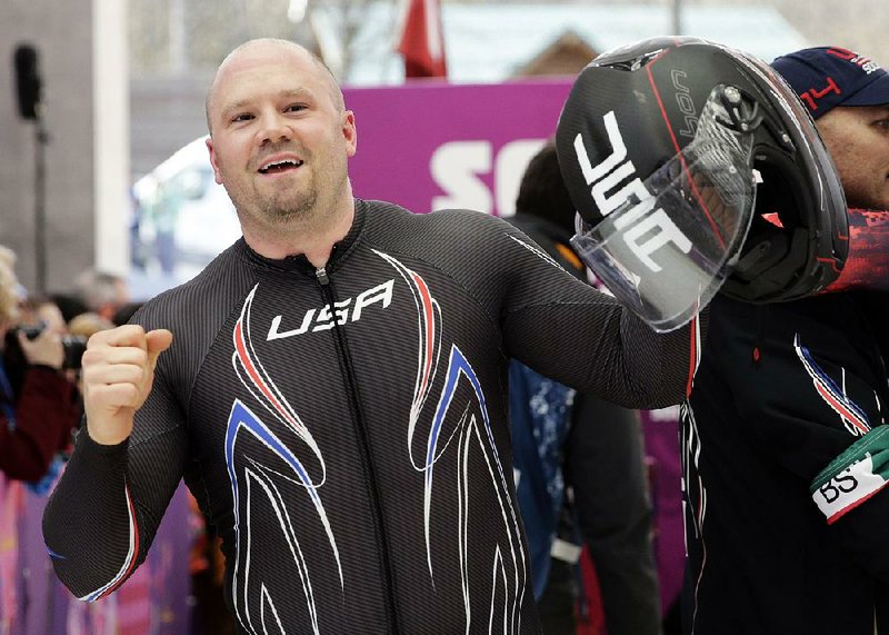 Steven Holcomb acknowledges the crowd after the team won the bronze medal during the men’s four-man bobsled competition final at the 2014 Winter Olympics. Holcomb, who died in 2017, and the United States four- and two-man bobsled teams will be awarded silver medals after the Russians were stripped of their gold medal in a doping scandal.