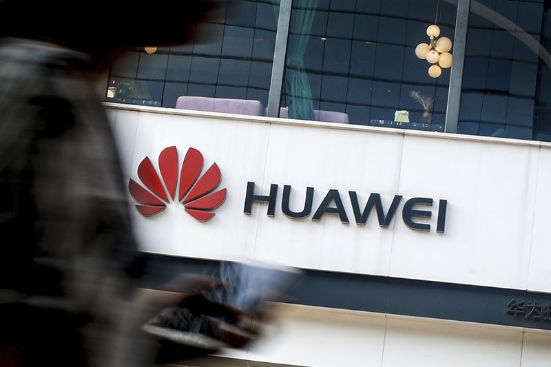 FILE - In this July 30, 2019, file photo a woman walks by a Huawei retail store in Beijing. The Trump administration has extended for 90 more days a limited reprieve on U.S. technology sales to the Chinese technology giant Huawei. The U.S. government blacklisted Huawei in May, deeming it a national security risk so U.S. firms aren't allow to sell the company technology without government approval. But numerous loopholes have been exploited, including by U.S. semiconductor suppliers. And the administration says it&#x2019;s preparing to grand some exemptions. (AP Photo/Andy Wong, File)