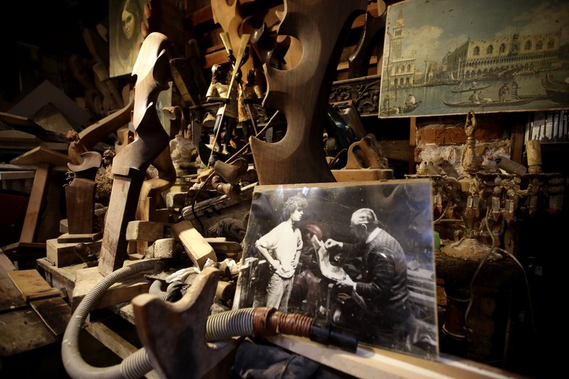 In this photo taken on Sunday, Nov. 17, 2019, wooden objects lean on a shelf at the Paolo Brandolisio oars laboratory, during an interview with the Associated Press, in Venice, Italy. Venetians are fed up with what they see as an inadequate to the city's mounting problems: record-breaking flooding, damaging cruise ship traffic and over-tourism. They feel largely left to their own devices, and with ever fewer Venetians living in the historic part of the city to defend its interests and keep it from becoming a theme park or museum.(AP Photo/Luca Bruno)