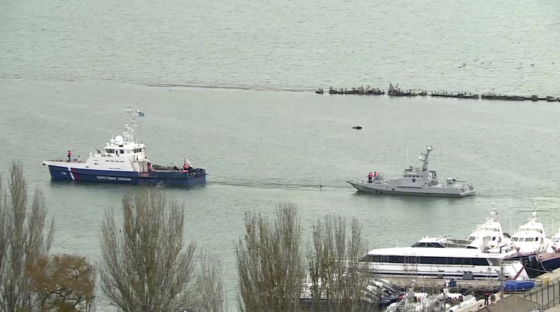 This video grab provided by the Krym 24 tv station via AP Television shows a seized Ukrainian ship, right, being towed by a Russian coast guard boat out of the port in Kerch, Crimea, Sunday, Nov. 17, 2019. Russia's Foreign Ministry says three Ukrainian naval ships that were seized in a shooting confrontation nearly a year ago have been returned. (Krym 24 tv station via AP Television)