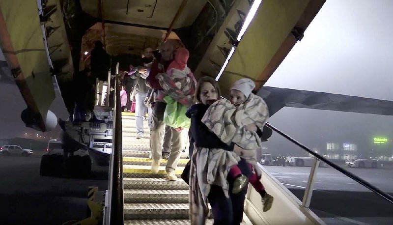 The repatriated children are carried off a plane Monday night at the Zhukovsky airport outside Moscow. 