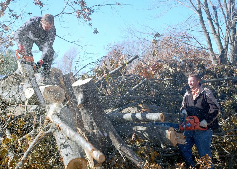 Marc Hayot/Herald Leader Workers from Christian Aid Ministries cut down one of the fallen trees on Edgewood Circle.