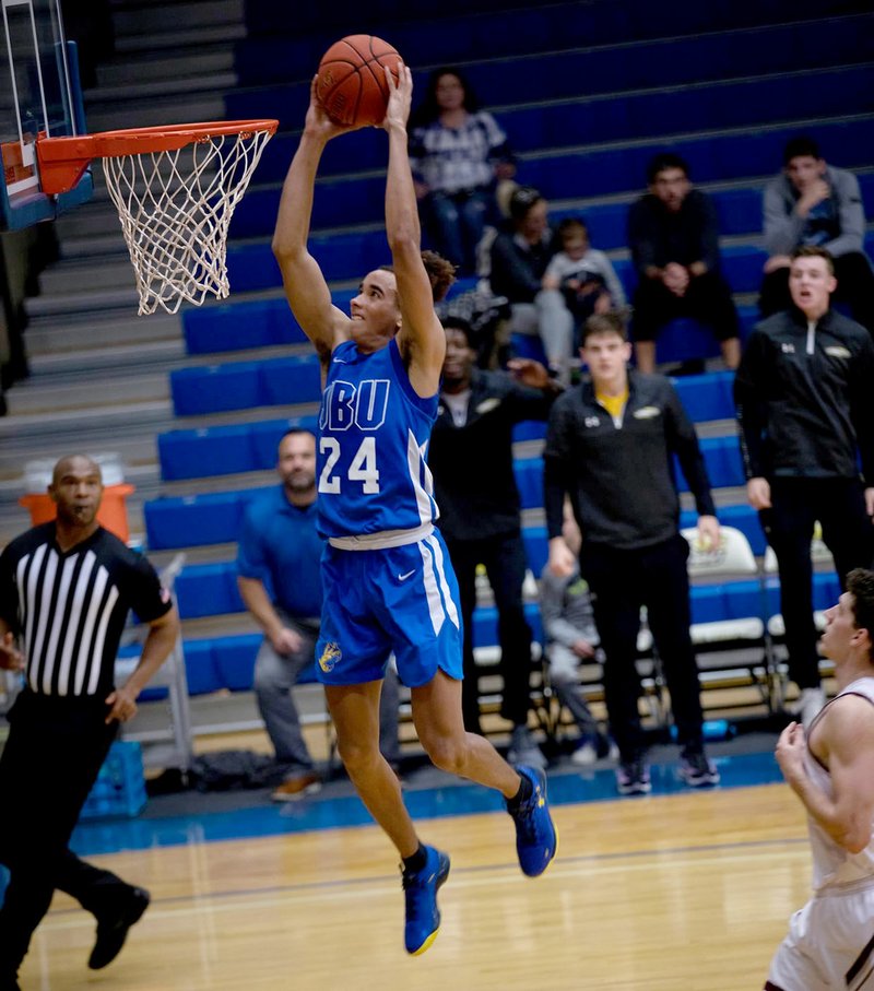 Photo courtesy of JBU Sports Information John Brown sophomore Ira Perrier goes in for a dunk against College of the Ozarks (Mo.) on Saturday during the JBU Classic at Bill George Arena.