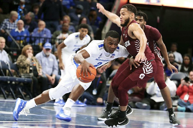 UALR sophomore guard Markquis Nowell (right) defends as Memphis sophomore guard Alex Lomax drives toward the basket during the No. 16 Tigers’ victory over the Trojans on Wednesday night at the FedEx Forum in Memphis. 