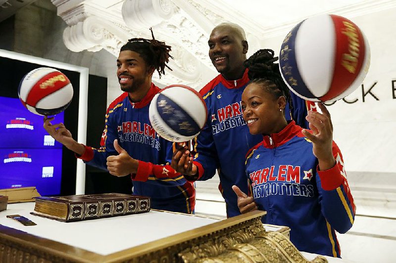 Harlem Globetrotters Donte “Hammer” Harrison (from left), Nathaniel “Big Easy” Lofton and Cherelle “Torch” George entertain traders Wednesday on the floor of the New York Stock Exchange before ringing the opening bell. 