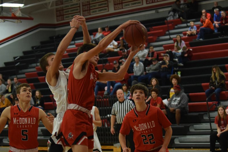 RICK PECK/SPECIAL TO MCDONALD COUNTY PRESS McDonald County's John Howard pulls down a rebound in front of Cale Adamson during a Red/Back Scrimmage held on Nov. 15 at MCHS. The Mustangs' first game of the season is set for Dec. 3 at home against Aurora.
