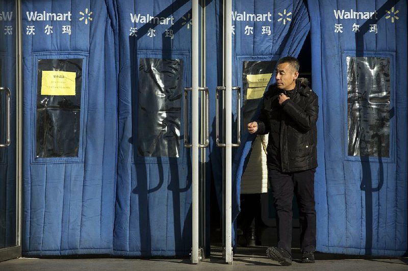 A shopper exits a Walmart store in Beijing in 2017. The retailer said Thursday that it plans to build 500 stores and distribution centers for its hypermarkets, supercenters and Sam’s Clubs over the next five to seven years. 