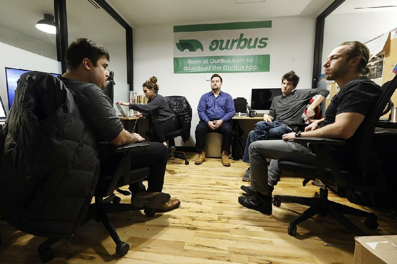 Employees of OurBus intercity and commuter bus service meet in their WeWork office space in New York earlier this month. Office-sharing company WeWork said Thursday that it is cutting 2,400 jobs globally. Video is available at arkansasonline.com/1122wework 
