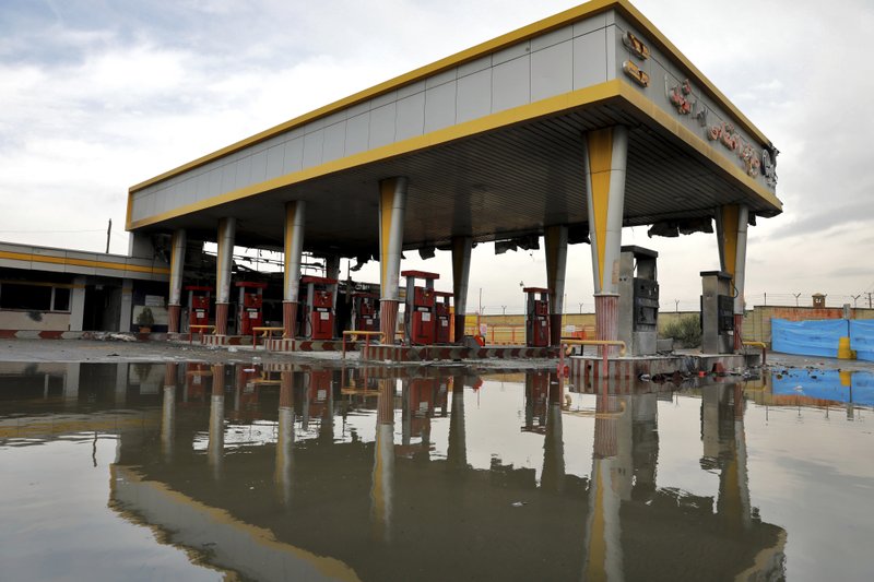 A gas station that was attacked during protests over rises in government-set gasoline prices is reflected in a puddle Wednesday in Tehran, Iran. Internet connectivity is trickling back in Iran after the government shut down access to the rest of the world for more than four days in response to unrest apparently triggered by a gasoline price hike. - AP Photo/Ebrahim Noroozi