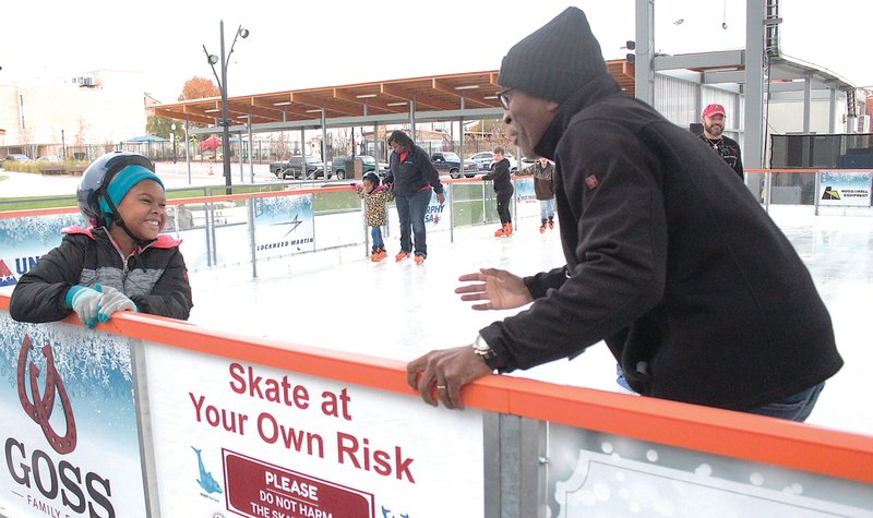 Skating monitor Richard Dunlap, right, assists Alyssa Tucker at the grand opening of MAD on Ice at the Murphy Arts District Amphitheater in 2019. The activity will return in November. (Caitlan Butler/News-Times)