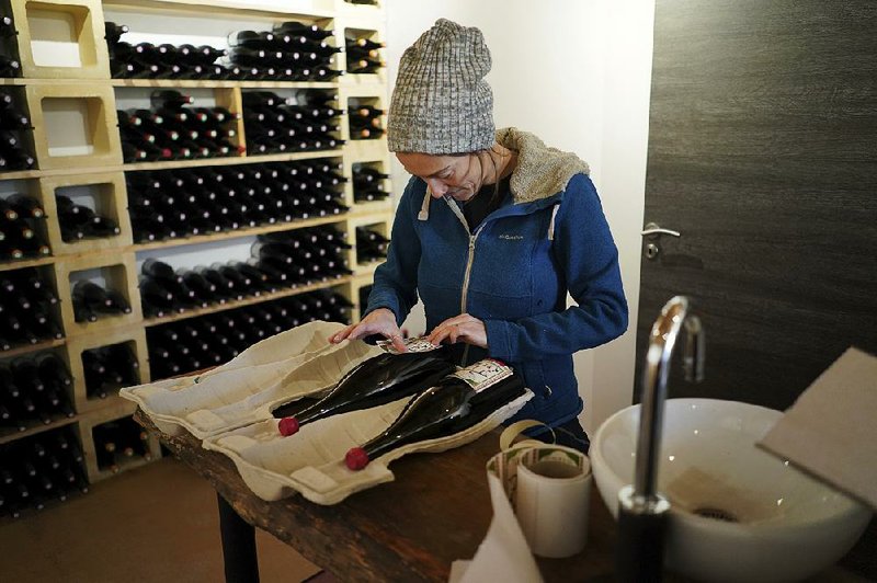 Winemaker Claire Chasselay places the labels on bottles of wine in her cellar in Chatillon d’Azergues, in the Beaujolais region of eastern France. 