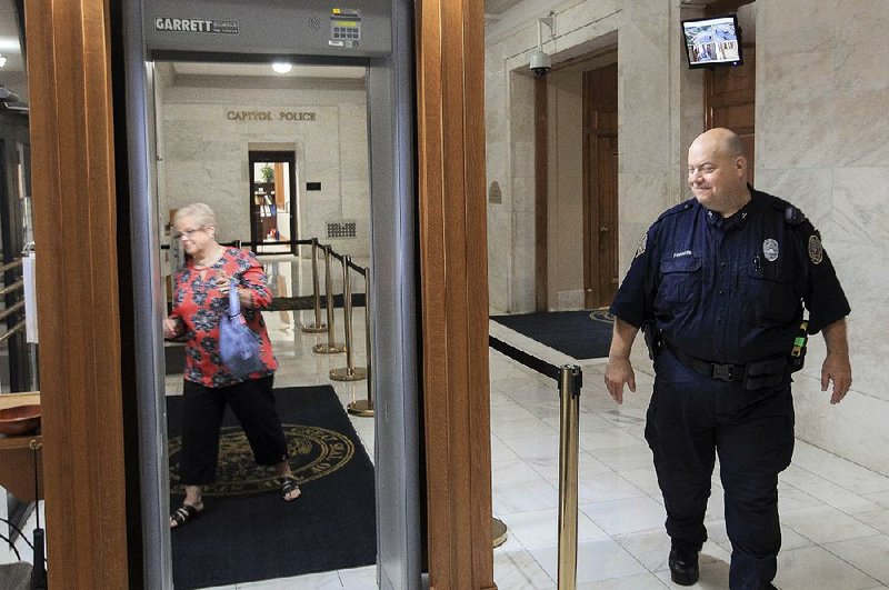 Brad Hartness of the State Capitol Police greets Jeannie McCarroll at an entrance to the Capitol in 2015. Some people, including lobbyists and others who don’t have offices in the Capitol, have been receiving electronic cards so they can avoid the security detectors, but a new policy by the secretary of state’s office will begin limiting the number of cards. 