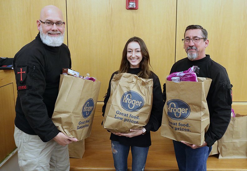 From left, Fearless Rock dive team members William Stevens, Suni Nichols and Eddie Rogers give out 20 Thanksgiving meals to families of juveniles in the H.E.R.O.S. drug treatment program Thursday at Garland County Juvenile Court. - Photo by Richard Rasmussen of The Sentinel-Record