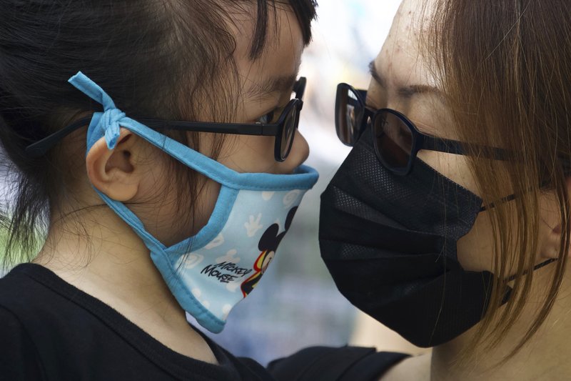 A woman holds a child during a rally to protest against the exposure of children to tear gas by police in Hong Kong, Saturday, Nov. 23, 2019. President Donald Trump on Friday wouldn't commit to signing bipartisan legislation supporting pro-democracy activists in Hong Kong as he tries to work out a trade deal with China. (AP Photo/Ng Han Guan)