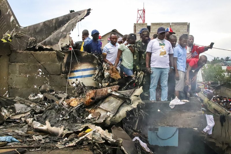 Rescuers and onlookers gather amidst the debris of an aircraft operated by private carrier Busy Bee which crashed in Goma, Congo on Sunday, Nov. 24, 2019.