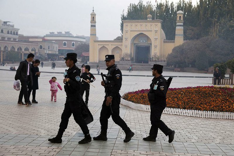 Uighur security personnel patrol near the Id Kah Mosque in western China’s Xinjiang region in this 2017 file photo.