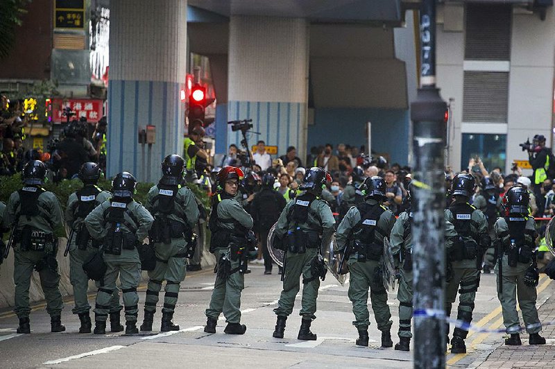 Riot police stand guard Monday at Hong Kong Polytechnic University as some of the city’s newly elected district council members meet with protesters. More photos are available at arkansasonline.com/1126hongkong/. 