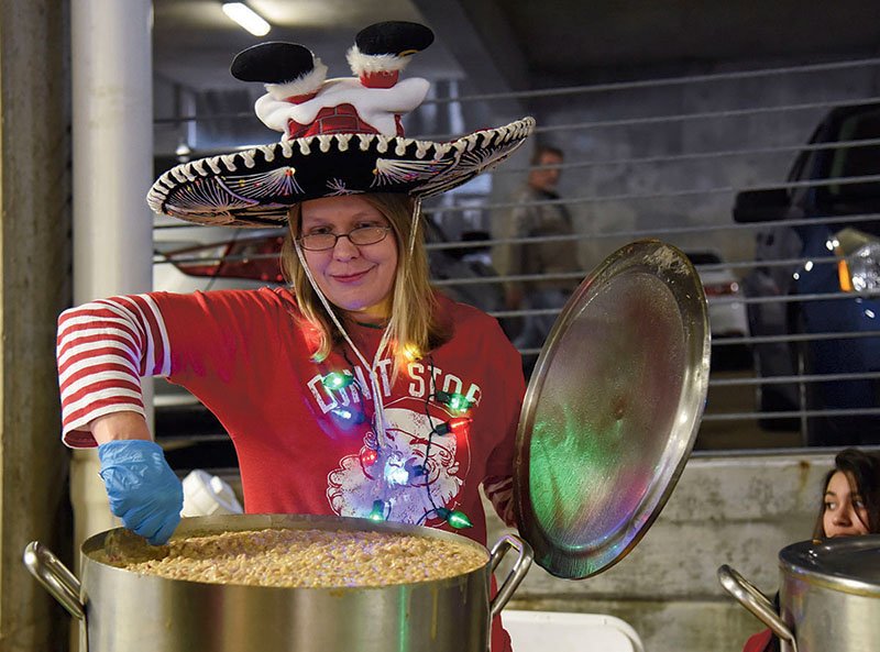 Carmen Jones with the Arlington Resort Hotel & Spa stirs a pot of chili at the Tom Daniel Holiday Chili Cook Off in the Exchange Street Parking Plaza in November 2019. - Photo by Grace Brown of The Sentinel-Record