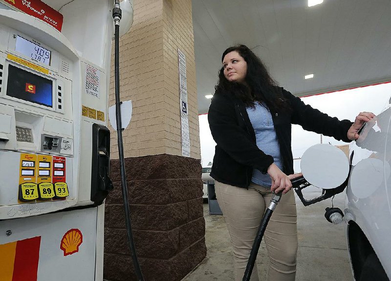 Stacey Megargee fills up Tuesday in downtown Little Rock. With the strong economy and low gas prices, more travelers are expected this Thanksgiving.