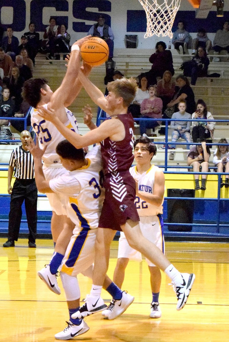 Westside Eagle Observer/MIKE ECKELS Pioneer Beau Tomblin (3, center) tries to block Kevin Garcia's (Decatur 25) shot attempt during the Thursday night Decatur-Gentry boys basketball contest at Peterson Gym in Decatur.