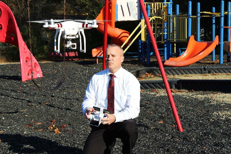 Retired Senior Master Sgt. Mark S. Evans shows how to fly a drone at the play- ground of the Boys & Girls Club of Jacksonville. The club is celebrating its 50th anniversary with a Dec. 20 gala at Jacksonville Community Center. 