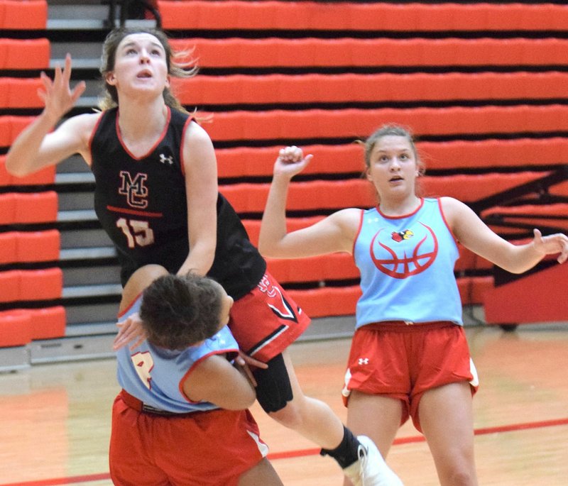 RICK PECK/SPECIAL TO MCDONALD COUNTY PRESS McDonald County's Ragan Wilson looks to see if her shot goes in while avoiding a charging foul during the Lady Mustangs scrimmage against Webb City on Nov. 18 at Webb City High School.