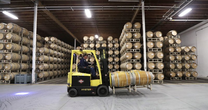 In this photo taken Thursday, Nov. 21, 2019, barrels of wine are moved into storage at Chateau Ste. Michelle winery in Woodinville, Wash. From less than 20 wineries in 1981, the Washington wine industry has grown to more than 1,000 this year. And the growth is likely to continue. (AP Photo/Elaine Thompson)