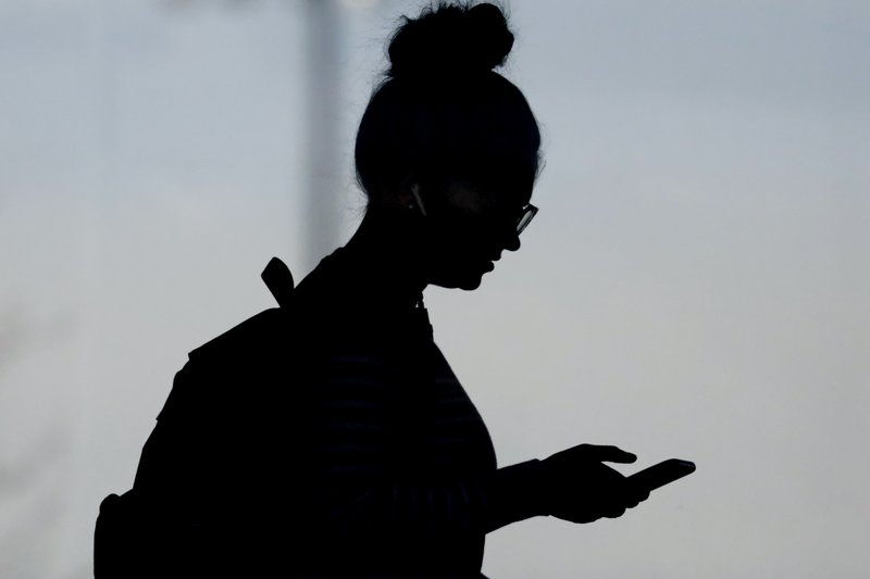 The Associated Press CHECKING IN: In this Nov. 14 file photo, a woman checks her phone in Orem, Utah. A new poll from The Associated Press-NORC Center for Public Affairs Research and USAFacts finds that Americans are getting information about government from social media at least as much as from traditional news sources, but few trust what they see and read. story.lead_photo.caption