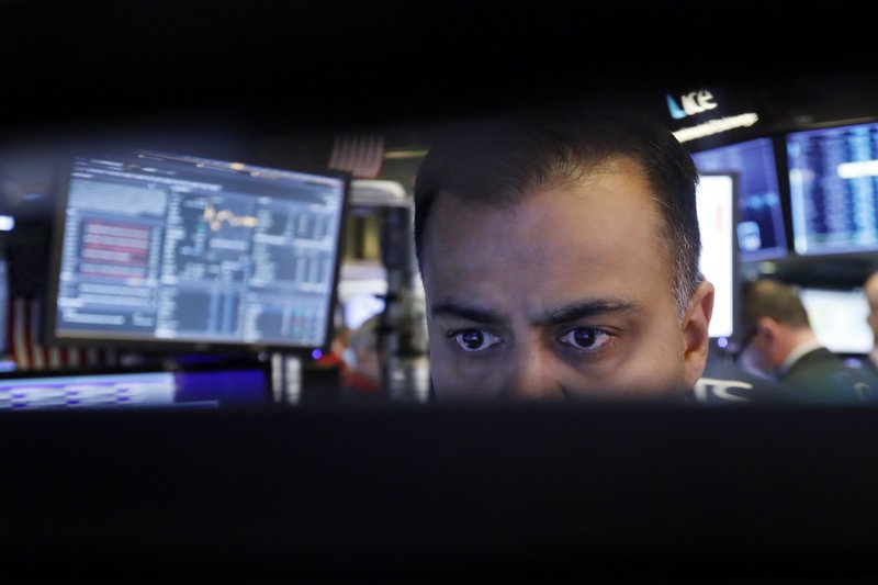 In this Nov. 20, 2019, file photo specialist Dilip Patel watches the screens at his post on the floor of the New York Stock Exchange.  (AP Photo/Richard Drew, File)