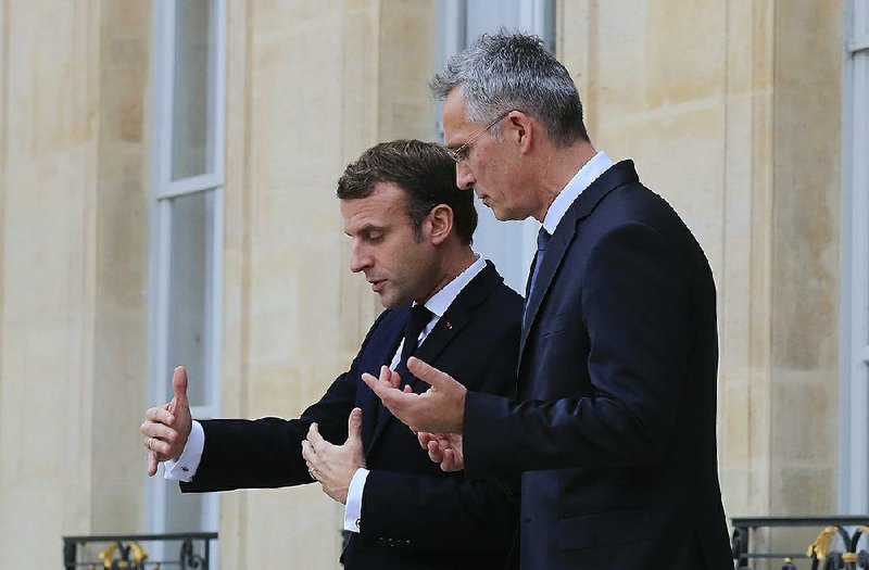 French President Emmanuel Macron (left) and NATO Secretary General Jens Stoltenberg talk Thursday as they leave a meeting at the Elysee Palace in Paris. 