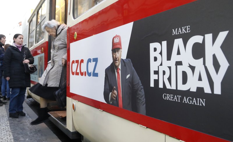 A woman gets off a tram advertising the Black Friday in Prague, Czech Republic, Thursday, Nov. 28, 2019. (AP Photo/Petr David Josek)