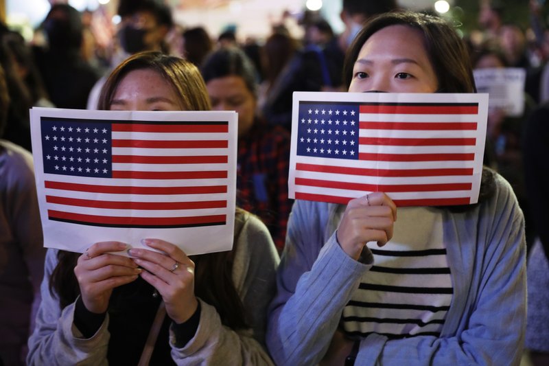 Protester holds U.S. flags during a demonstration in Hong Kong on Thursday. China's fury over President Donald Trump's decision to sign legislation supporting human rights in Hong Kong is evident. What's less clear what "countermeasures" Beijing may take in response to what it said Thursday were "extremely evil" and dangerous moves. - AP Photo/Vincent Thian