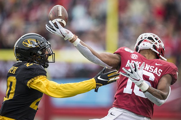Arkansas receiver Treylon Burks tries to catch a pass while Missouri defensive back Khalil Oliver covers him during a game Friday, Nov. 29, 2019, in Little Rock.
