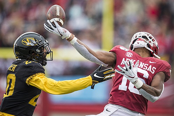 Arkansas receiver Treylon Burks tries to catch a pass while Missouri defensive back Khalil Oliver covers him during a game Friday, Nov. 29, 2019, in Little Rock. 