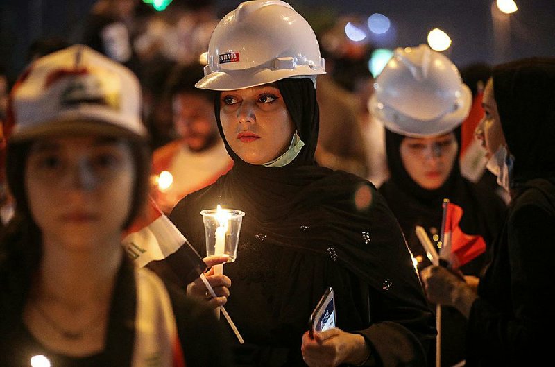 Iraqi women light candles Friday in Basra in memory of slain anti-government protesters. 