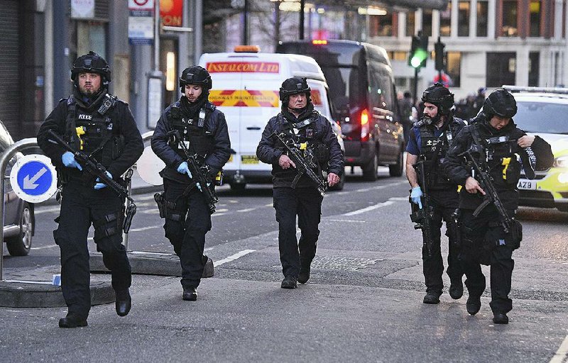 Police patrol Cannon Street in London near the scene where an attacker with a knife stabbed people on London Bridge and then was fatally shot by officers. More photos are available at arkansasonline.com/1130london 