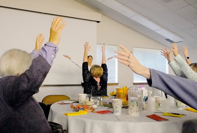 NWA Democrat-Gazette/ LYNN ATKINS Nancy Keesling, a yoga instructor at Riordan Hall in Bella Vista, gives a demonstration of chair yoga for the Christian Women's Connection meeting at Bella Vista Community Church.