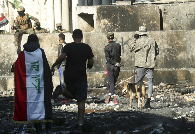 Iraqi security forces and anti-government protesters rest after both sides shake hands and converse in a rare moment of calm in hostilities called to allow time for rest after clashes in Baghdad, Iraq, Saturday, Nov. 30, 2019. 

