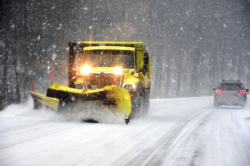 A snow plow on Sunday, Dec. 1, clears the road surface on Route 7 in New Ashford, Mass.