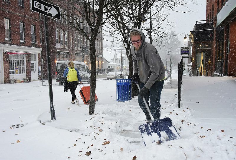 Landscaping employee Zach Lusignan shovels snow Sunday from a street in Williamstown, Mass. Parts of the Northeast were expecting more than a foot of snow from a deadly winter storm moving into the region. 