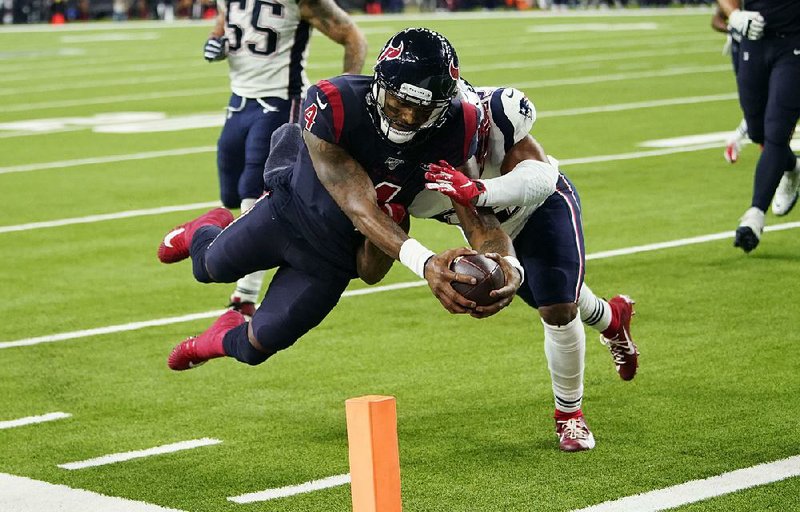 Houston quarterback Deshaun Watson dives past New England outside linebacker Elandon Roberts to score the first receiving touch- down of his career in a 28-22 victory over the Patriots on Sunday in Houston. Watson also threw for three touchdown passes. story.lead_photo.caption