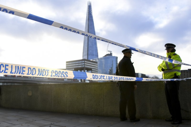 Police officers patrol the scene in central London, Sunday, Dec. 1, 2019, after an attack on London Bridge on Friday. Authorities in Britain say the convicted terrorist who stabbed to death two people and wounded three others in a knife attack Friday had been let out of prison in an automatic release program. (AP Photo/Alberto Pezzali)