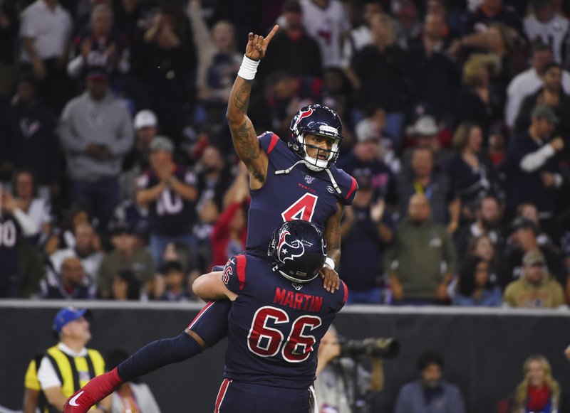 Houston Texans quarterback Deshaun Watson (4) is lifted by center Nick Martin (66) as they celebrate a touchdown against the New England Patriots during the first half of Sunday's game in Houston. - Photo by Eric Christian Smith of The Associated Press