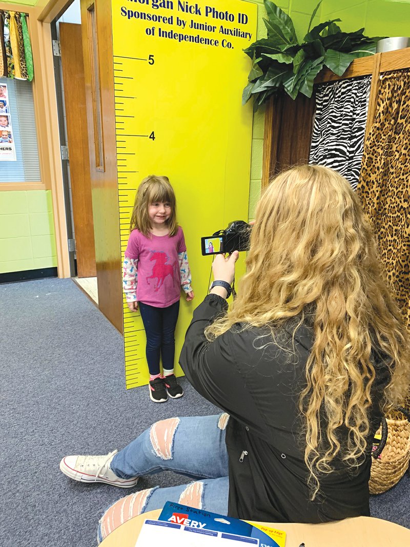 Batesville Junior High School student Carissa Cordell takes a photo of preschooler Fallon Hawkins to be included in a child identification kit. Junior high EAST students came to the Batesville preschool Friday to fingerprint and photograph children and collect a strand of their hair for DNA purposes.