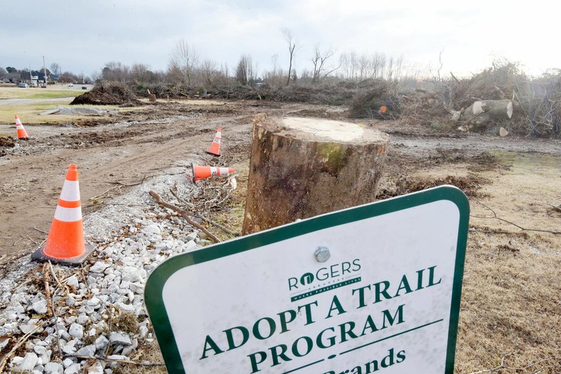 NWA Democrat-Gazette/FLIP PUTTHOFF Property at the Blossom Way trailhead in Rogers is a dump site in late November for trees and branches picked up by city workers after the October tornado.