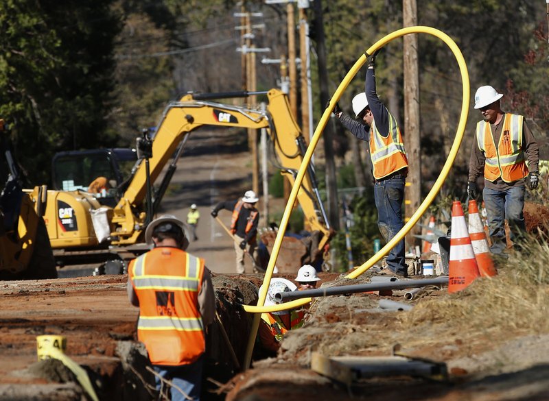 FILE - In this Oct. 18, 2019, file photo, Pacific Gas and Electric Company, workers bury utility lines in Paradise, Calif. A new technology being tested by California utilities, such as Pacific Gas &amp; Electric Co. and Southern California Edison, is aimed at diagnosing problems before they could cause power outages or spark wildfires. (AP Photo/Rich Pedroncelli, File)