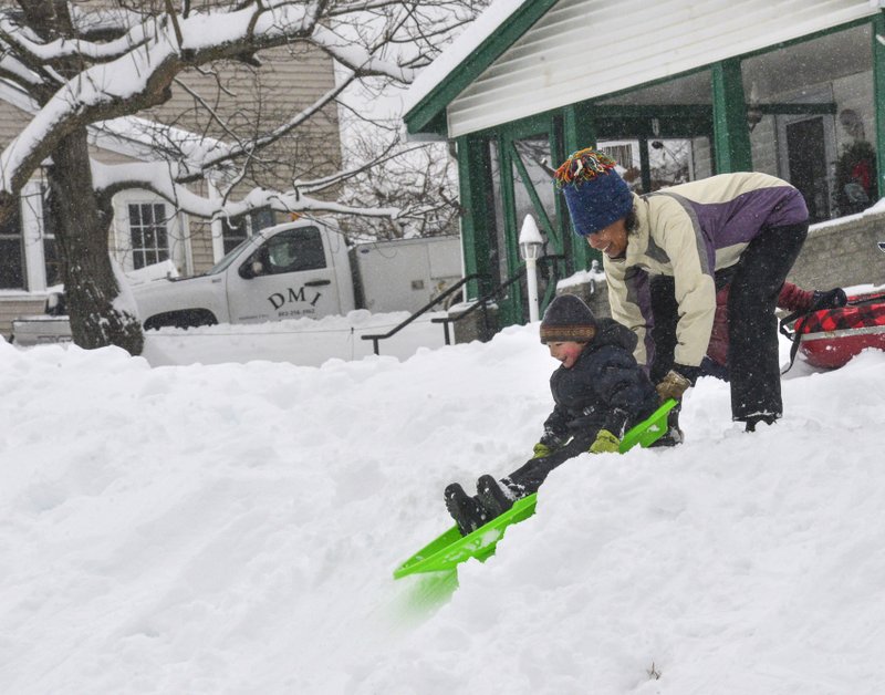 Edisa Weeks gives her 5-year-old nephew, Niko Brown, a push down a hill at the Brattleboro Little League Field, in Brattleboro, Vt., on Monday, Dec. 2, 2019. A final wallop of a seemingly endless winter storm that impacted most of the country over the long holiday weekend is bearing down on the East, dumping heavy snow, shuttering schools and stymieing travel in the region Monday. (Kristopher Radder/The Brattleboro Reformer via AP) story.lead_photo.caption