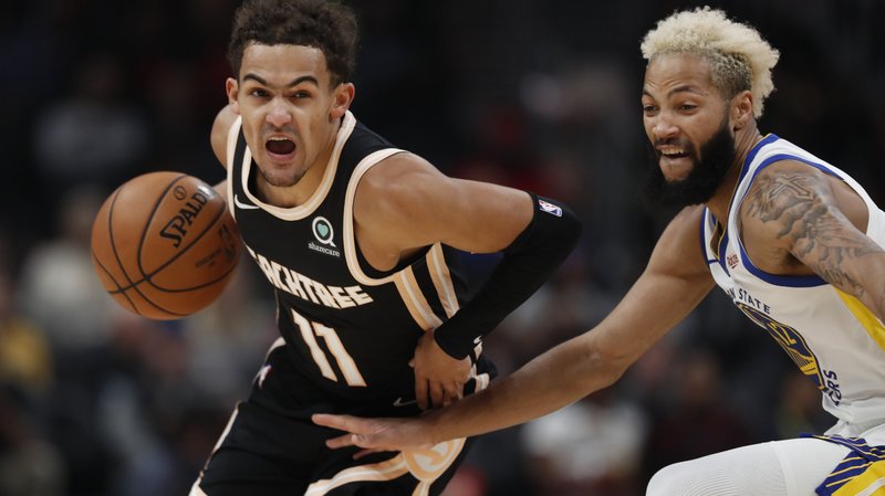 Atlanta Hawks guard Trae Young (11) drives against Golden State Warriors guard Ky Bowman (12) in the first half of Monday's game in Atlanta. - Photo by John Bazemore of The Associated Press story.lead_photo.caption